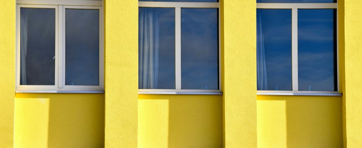 yellow concrete building with glass windows