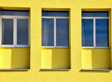yellow concrete building with glass windows